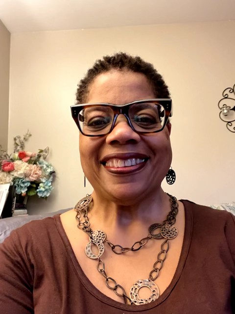 A casual selfie of voice actor Renee Garner Elms in her home. She is wearing a brown blouse and large brown necklace